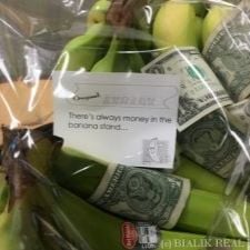 Bananas and rolled dollar bills in a clear bag with a card quoting “There's always money in the banana stand.”