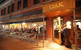 Oak restaurant storefront with large windows and diners inside.