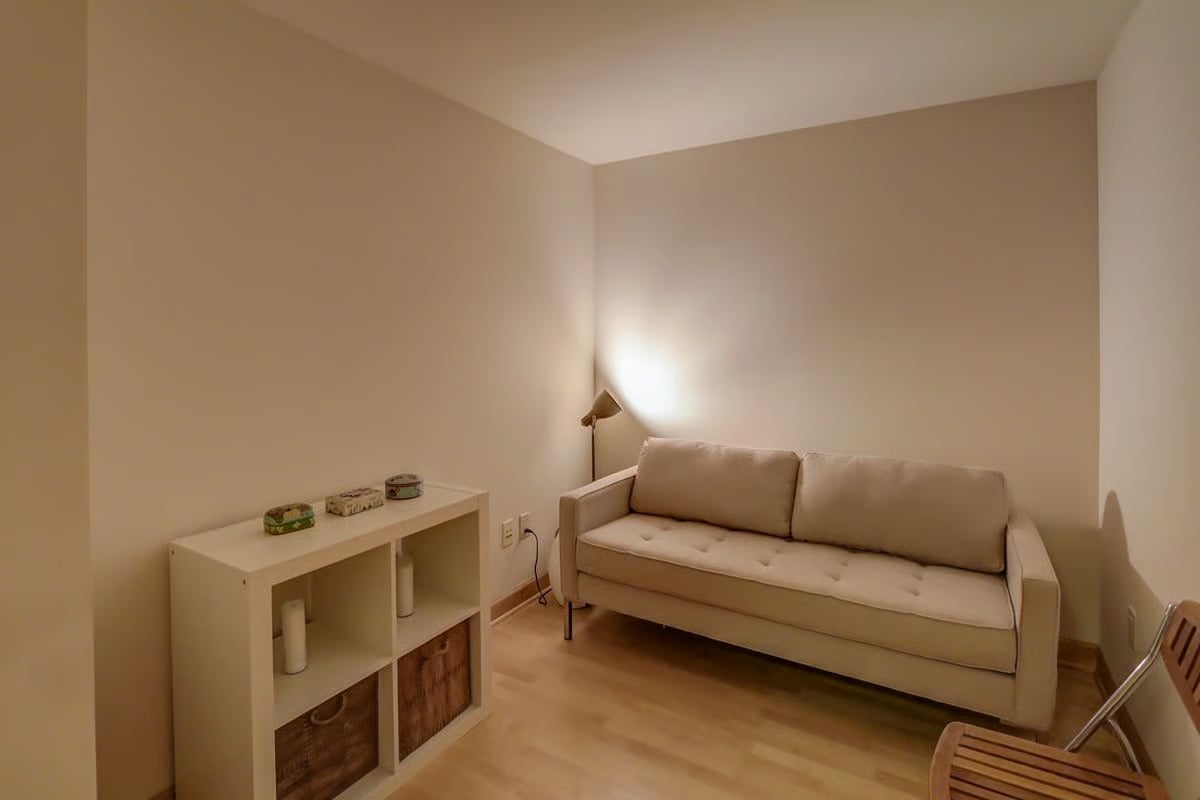Furnished sitting room with a cream sofa, white cubby console, and floor lamp.