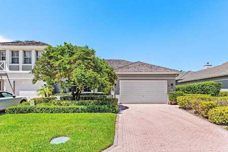 Home with a two-car garage, brick-paver driveway, and landscaped front lawn.