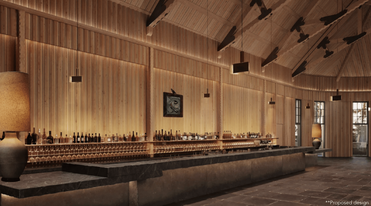 Bar interior with a long stone counter, rows of bottles, and warm wood paneling.