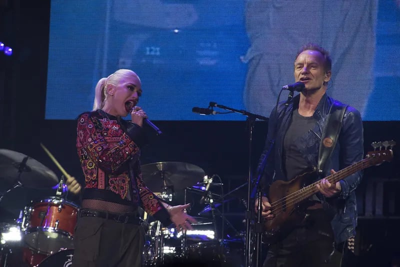 Gwen Stefani and Sting performing live on stage during a major stadium concert at Oracle Park in San Francisco.