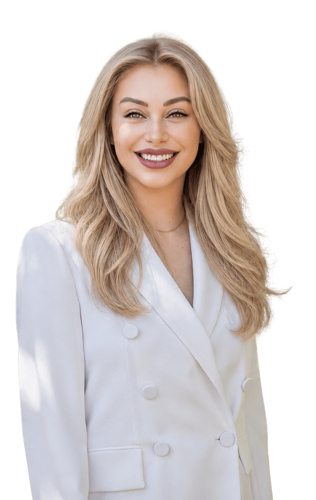Genesys Flores smiling in a white double-breasted blazer, with long blonde hair.