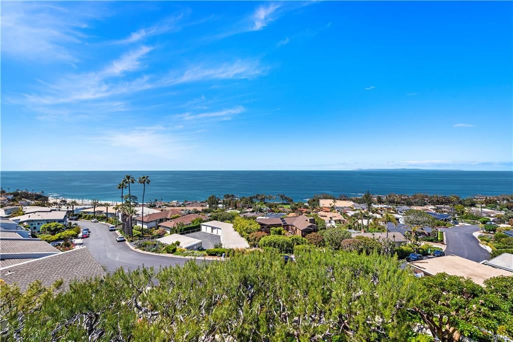 Coastal neighborhood overlooking the ocean beneath a bright blue sky.