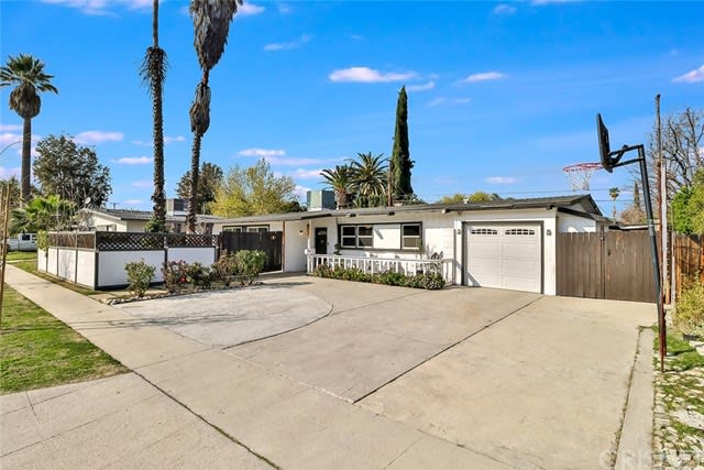 Photo of front of 19421 Hemmingway at an angle from the driveway. Great Ed Fickett Design with blue partly cloudy skies in background