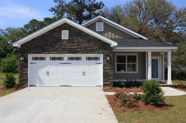 A modern single-story house in 5628 Jacksons Gap Rd with a combination of brick and siding exterior. The property features a driveway, garage, and minimal landscaping in the front yard.