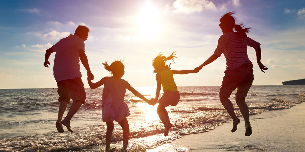 a happy family jumping under the sunrise