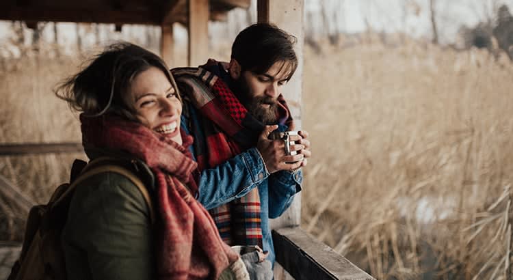 a warm and intimate moment shared by two people outdoors, likely in a cold-weather setting. 