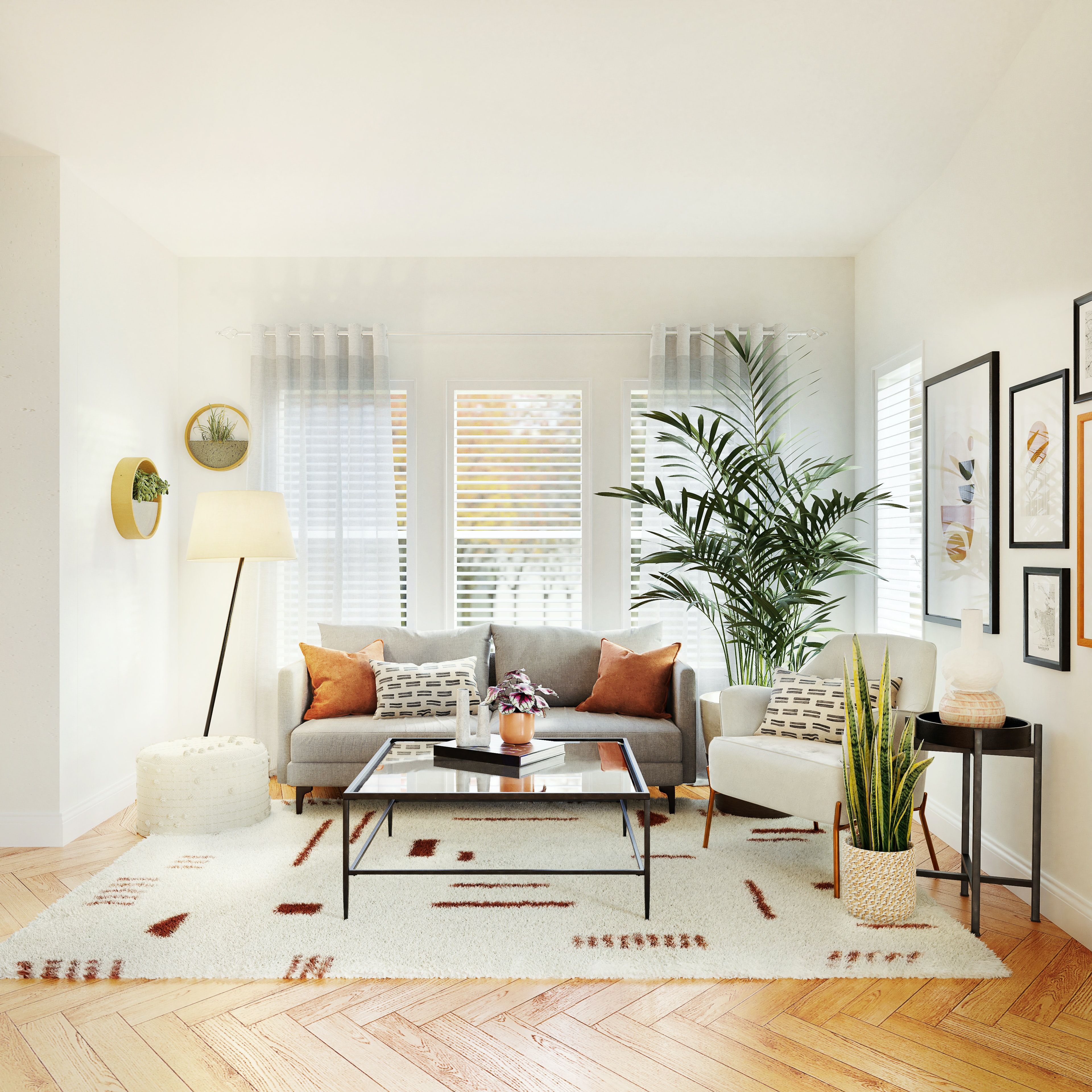 Bright living room with a gray sofa, white armchair, large plants, and shuttered windows.