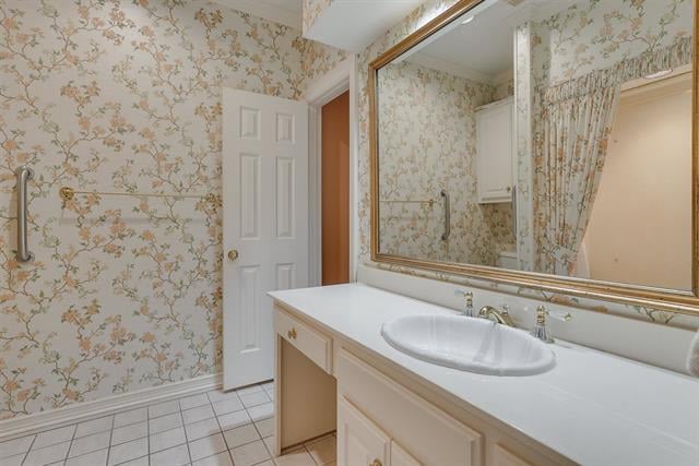 Bathroom with floral wallpaper, a long white vanity and a large framed mirror.