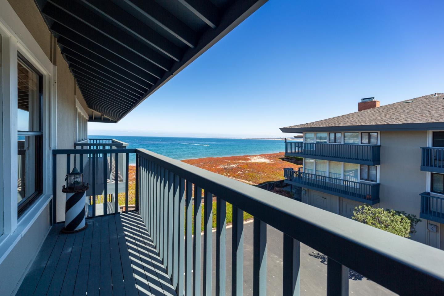 Balcony overlooking the ocean, with dark railings and a striped lantern.