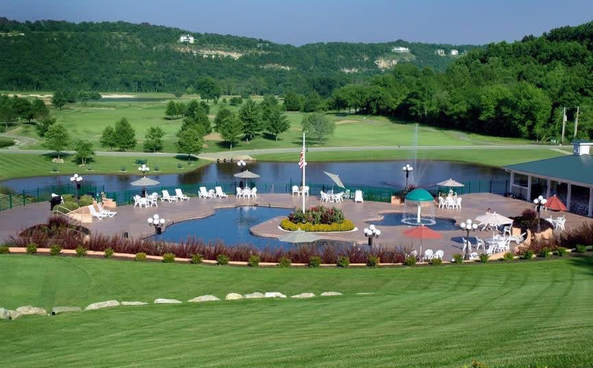 An aerial view of a golf course with a pool area below