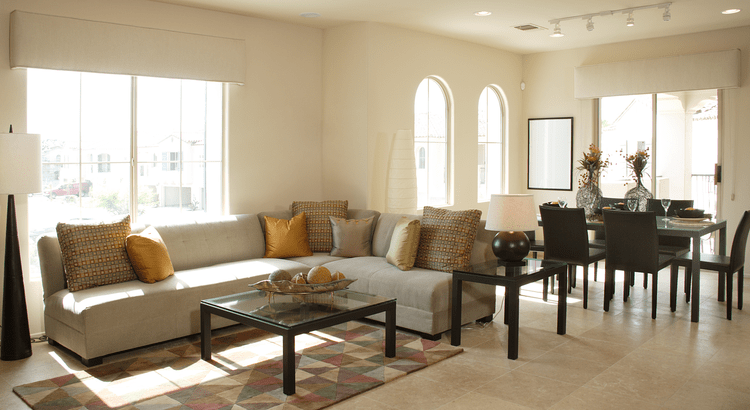 A living and dining room area with contemporary furnishings. The room is spacious and well-lit, with large windows and a comfortable seating arrangement.