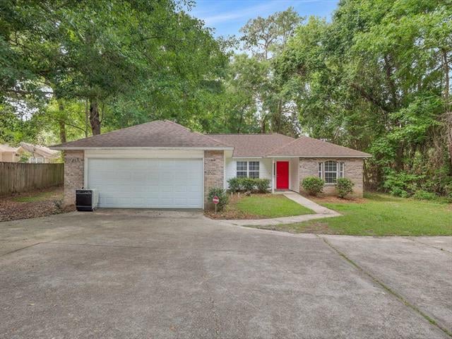 A single-story house in 8810 Minnow Creek Dr with a brick exterior and an attached garage. The front yard is well-maintained with a driveway and some landscaping near the entrance.