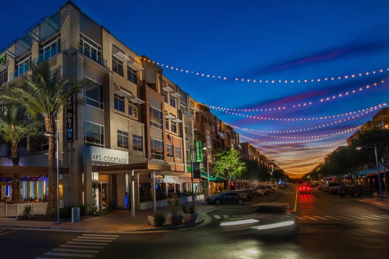 Modern townhomes and luxury estates shimmer under starry Desert Ridge skies.