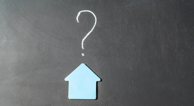 A blue house icon with a question mark above it on a chalkboard background.