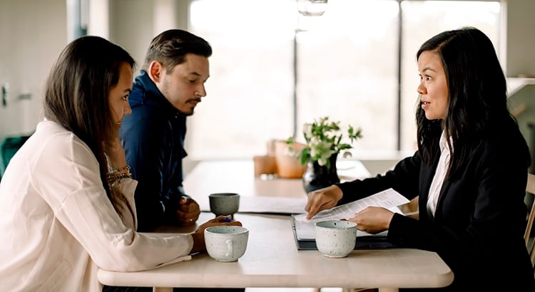 mortgage loan officer explaining documents to prospective buyers