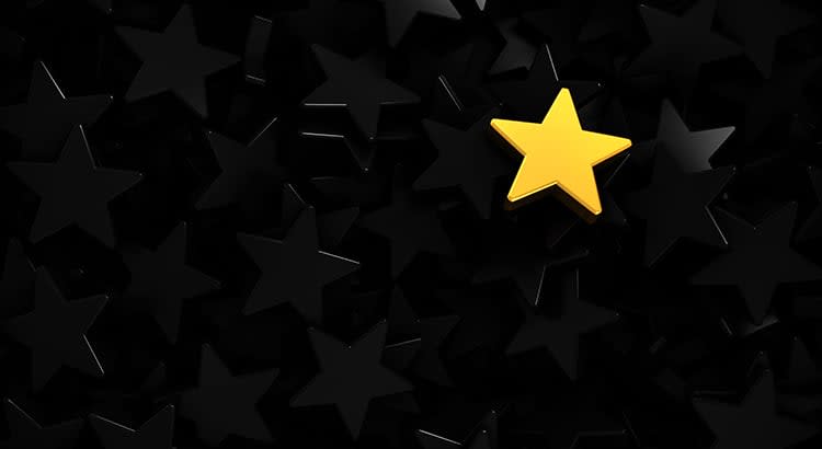 A standout yellow star among several black stars, which may symbolize uniqueness or success.