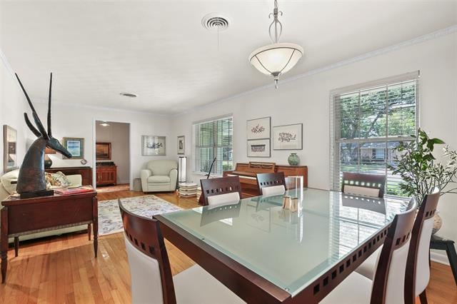 Dining room with a glass-top table, dark wood chairs, and an adjoining sitting area.