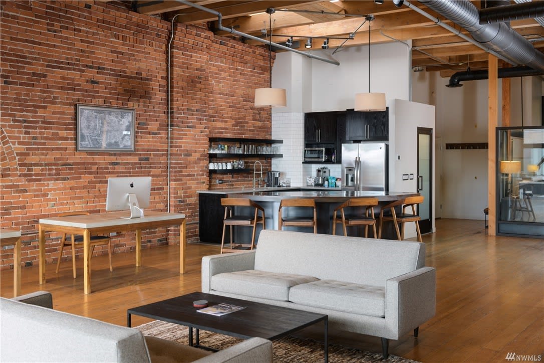 Chic loft with exposed brick, modern kitchen, and industrial touches, combining comfort with urban-style living.