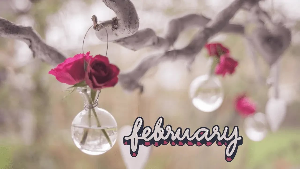 A close-up of a decorative piece with the word "February" and a hanging ornament with red flowers. This image represents the month of February and evokes a sense of seasonal or holiday decoration.