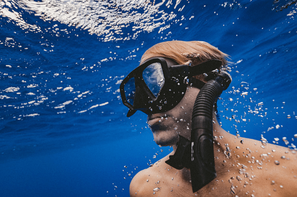 a man wearing a mask and diving in the ocean