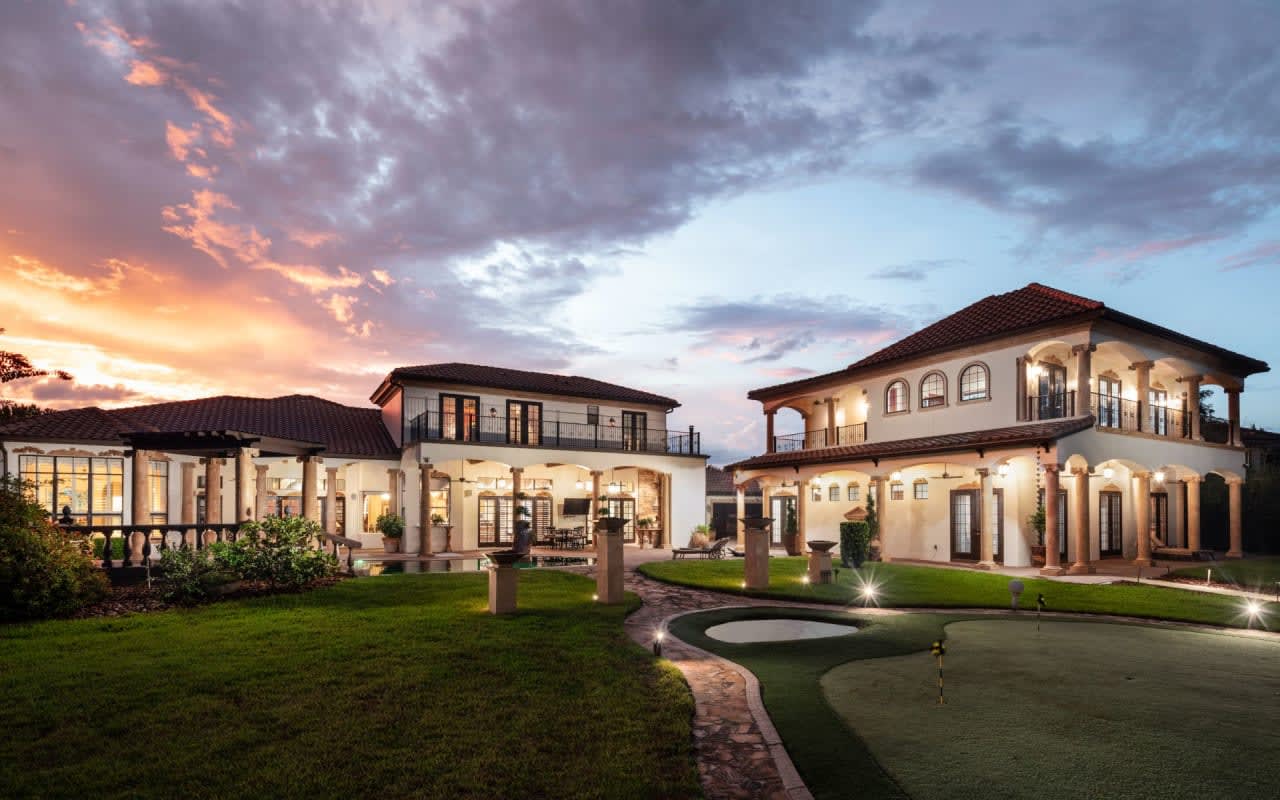 An expansive luxury estate with a meticulously manicured yard.