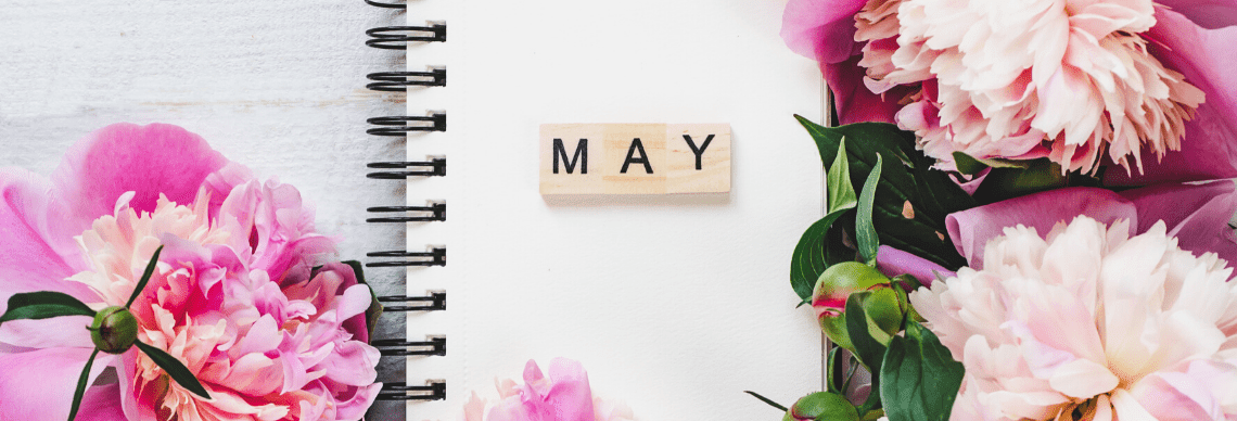 the word "MAY" alongside flowers and a notebook, reflecting a springtime theme. 