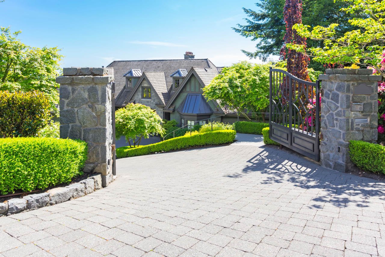 Elegant gated entry to a luxury home showcasing privacy and exclusive living in a lush landscape.