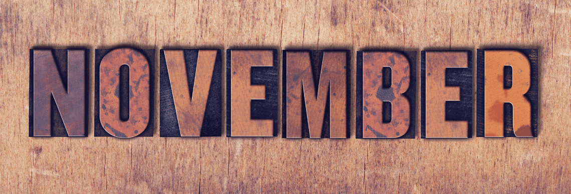 the word "NOVEMBER" prominently displayed using vintage wooden printing blocks, arranged on a rustic wooden surface.