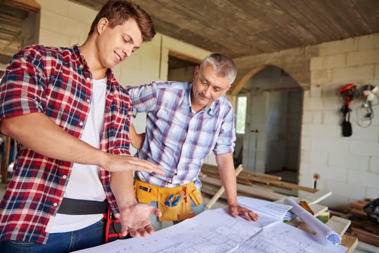 Two carpenters looking the blueprint