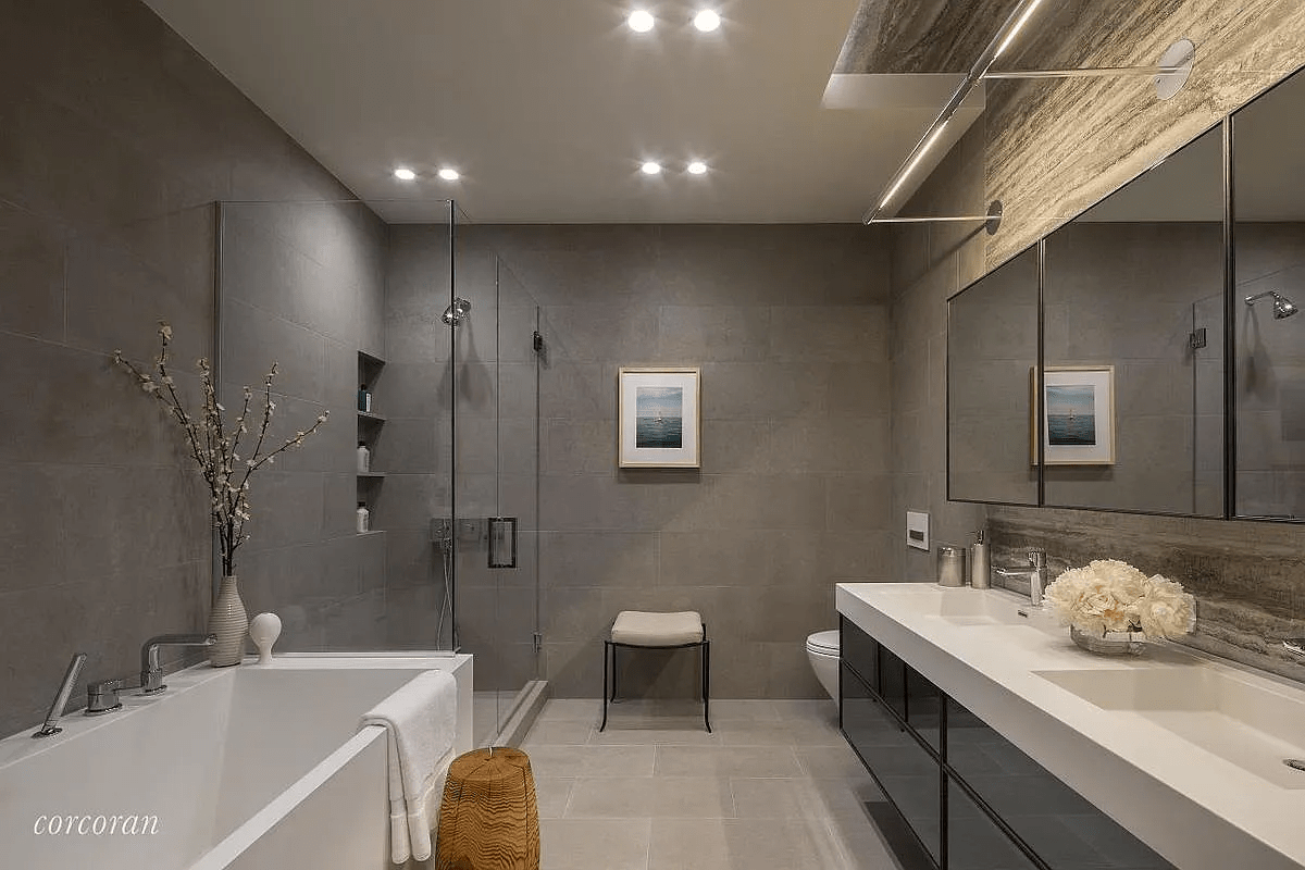 Contemporary bathroom with a soaking tub, glass shower, and long double vanity.