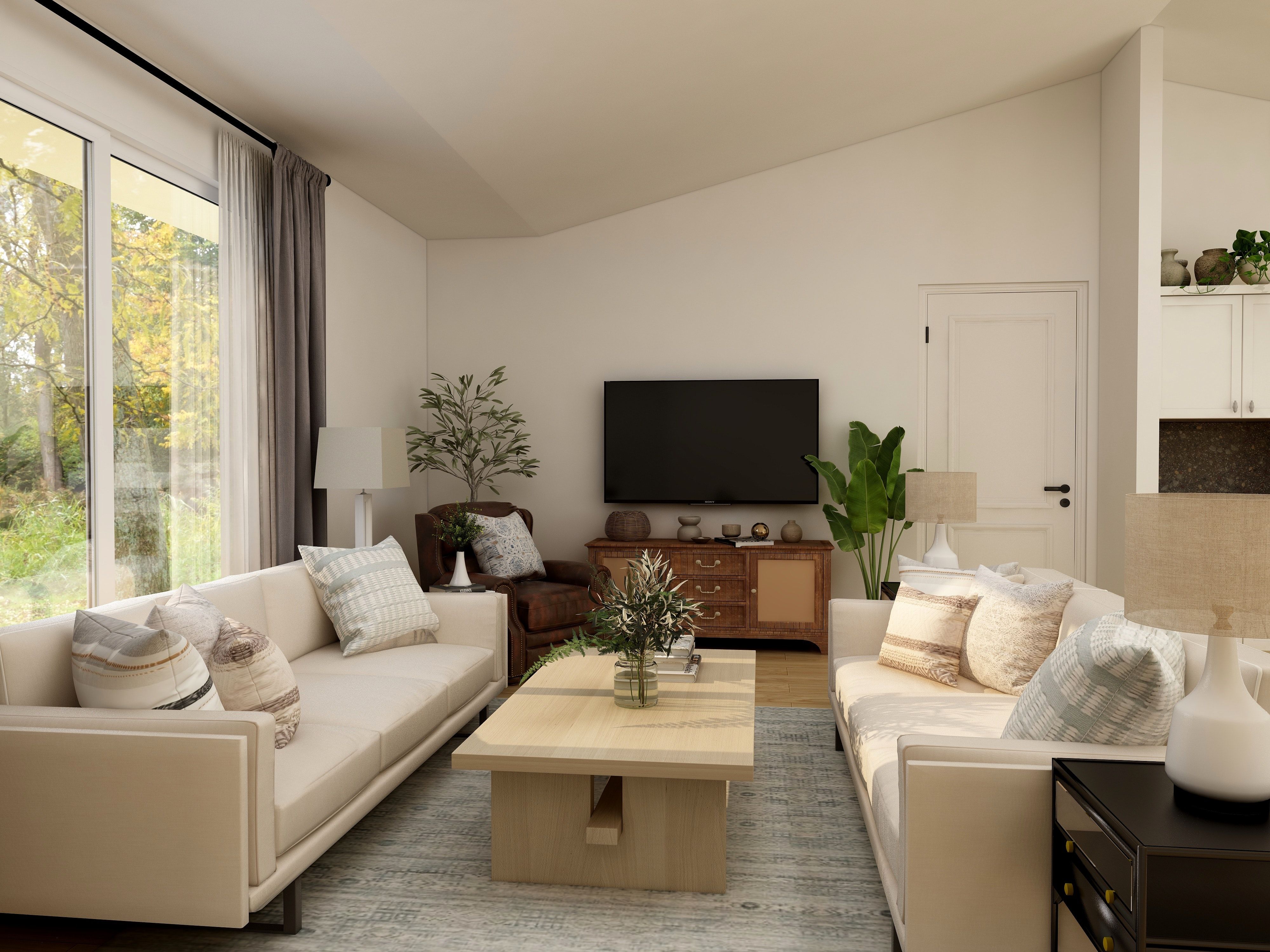 Living room with cream sofas, a wood coffee table, and large windows overlooking trees.