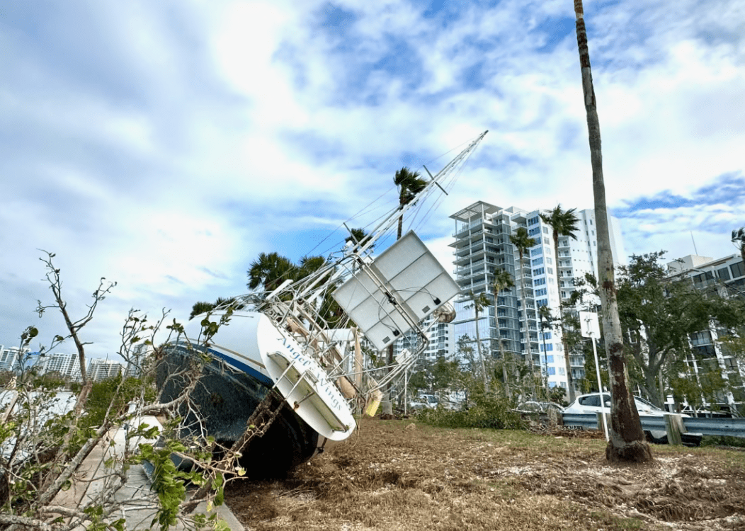  A boat, partially submerged and heavily damaged.
