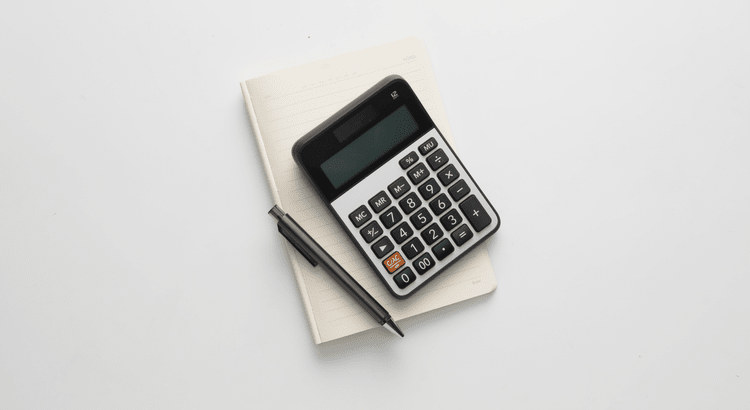 A calculator and a pen placed on a clean white background, symbolizing calculations and note-taking.