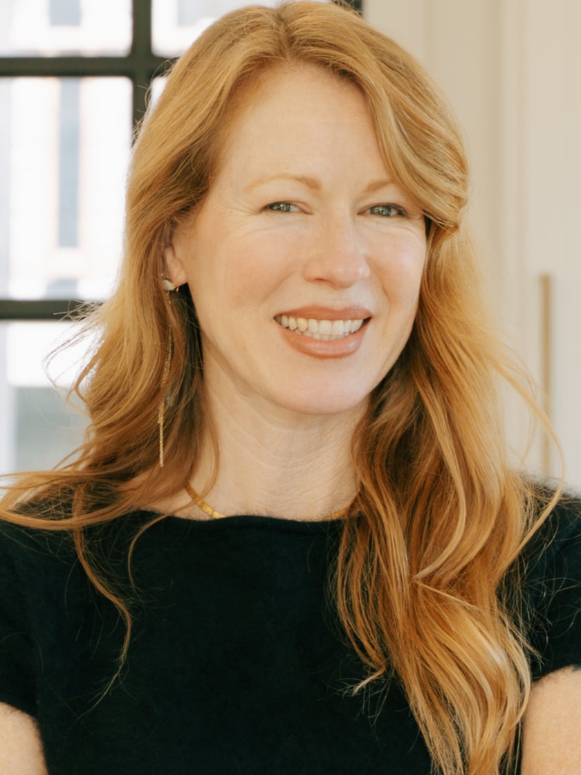 Jennifer Klein smiling in a black top, with long red hair.