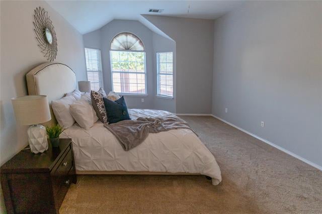 Bedroom with a large bed beneath an arched window and two narrow side windows.