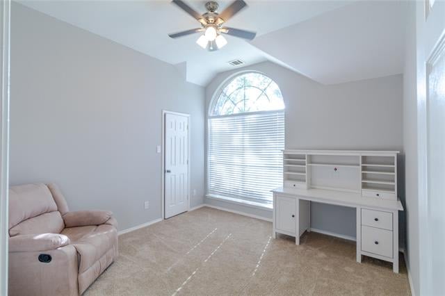 Carpeted room with an arched window, built-in desk, and pink reclining chair.