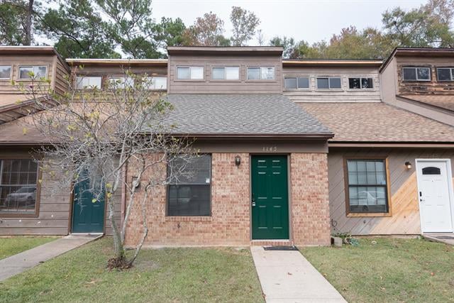 A townhouse with a brick exterior in 1145 Ocala Road. The front yard has a small grassy area and a walkway leading to the entrance.