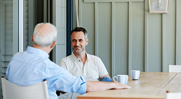 Two men, likely professionals, having a conversation over a table, suggesting a discussion related to real estate or finance.