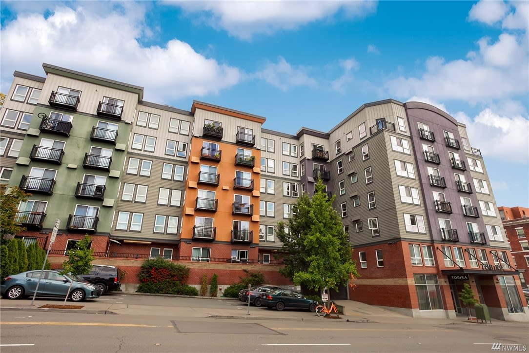 An upscale apartment building with spacious balconies and ample parking spaces.