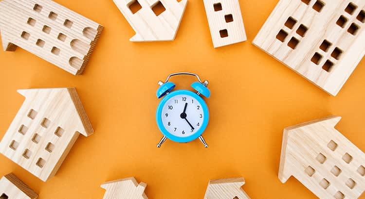 A bright and playful composition featuring a blue alarm clock, wooden blocks, and pieces of a puzzle on an orange background. This image has a lively and energetic vibe.