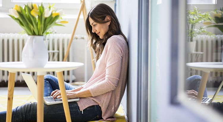 a woman sitting by a table, possibly studying or working on finances.