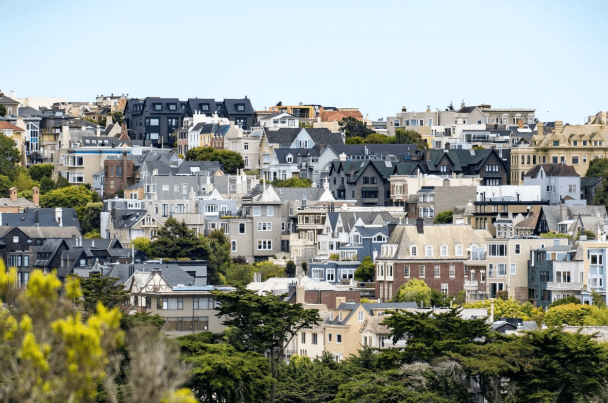 The houses are all different colors and styles, and they are all surrounded by trees.