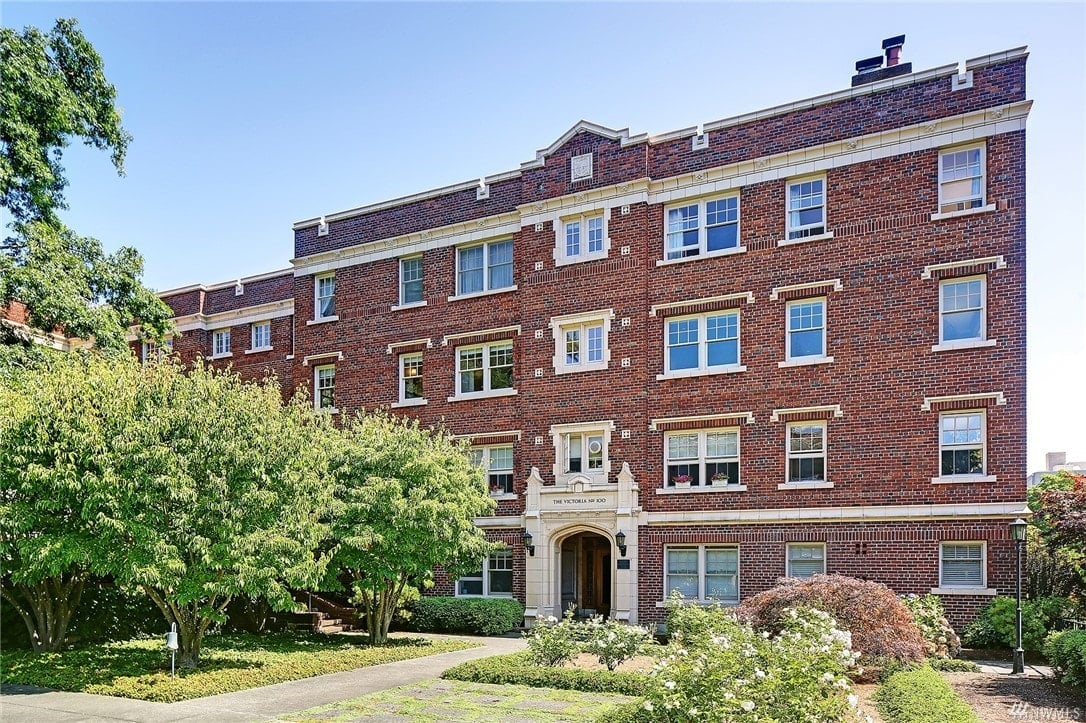 Classic brick condominium exudes elegance amid verdant surroundings, offering a timeless, luxurious abode.