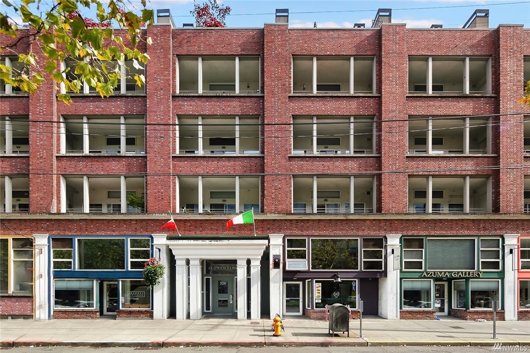 A picturesque red brick building with multiple windows situated on the street.