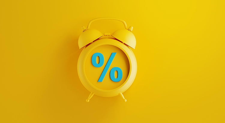 A yellow alarm clock with a percentage symbol on its face, set against a bright yellow background. This likely relates to mortgage rates or financial information.