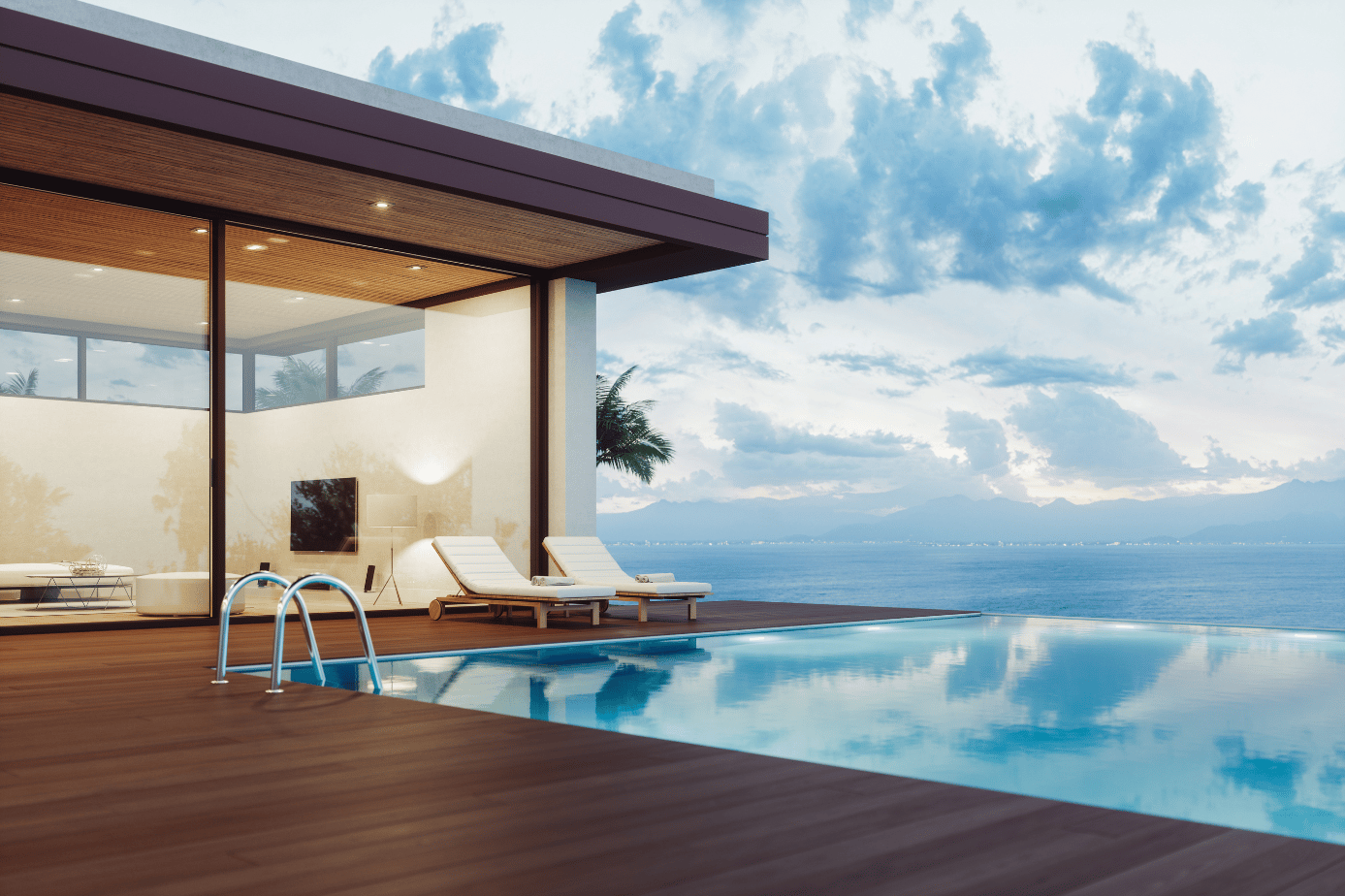 Modern waterfront home with an infinity pool, ocean and mountain views, and a wood deck.