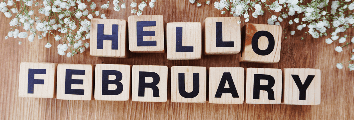 the cheerful message "HELLO FEBRUARY" spelled out using wooden letter blocks on a wooden surface, complemented by delicate white flowers.
