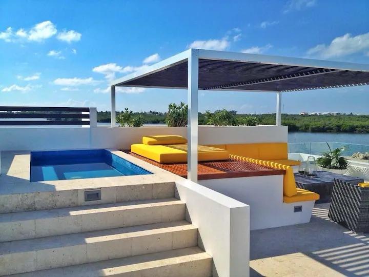 Unique tropical waterfront 3 bed 3 bath villa with a pergola and plunge pool on the rooftop terrace and with boat slip in a gated community on Ambergris Caye, Belize. 